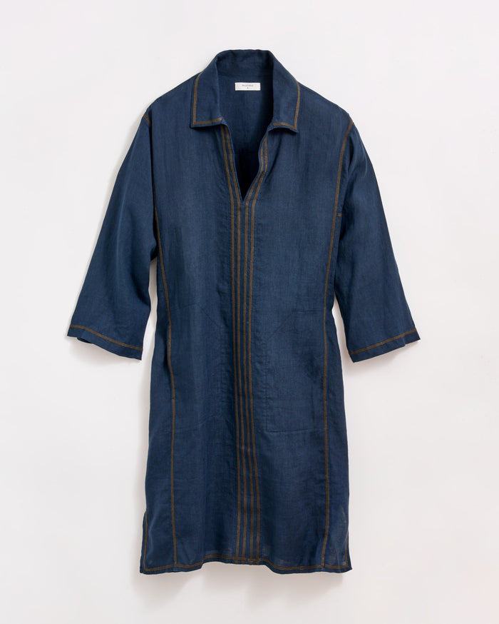 A knee-length, long-sleeve, dark blue denim dress with brown vertical stitching details and a collar, displayed against a plain white background.
