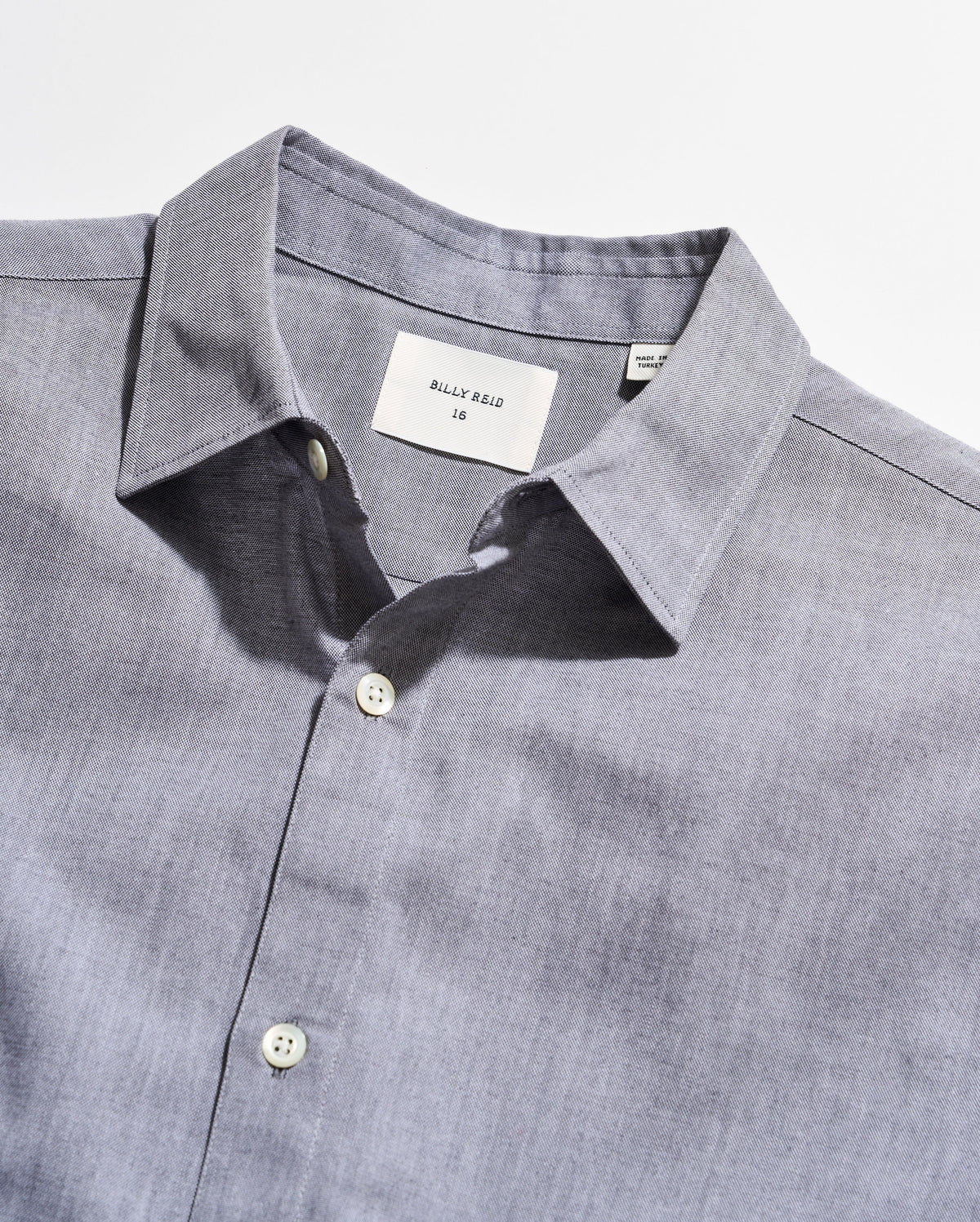 Close-up of a gray shirt with collar and buttons on a white background