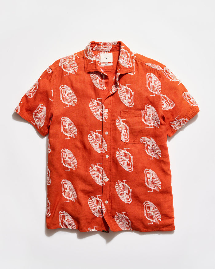 Orange shirt with white bird pattern on a white background
