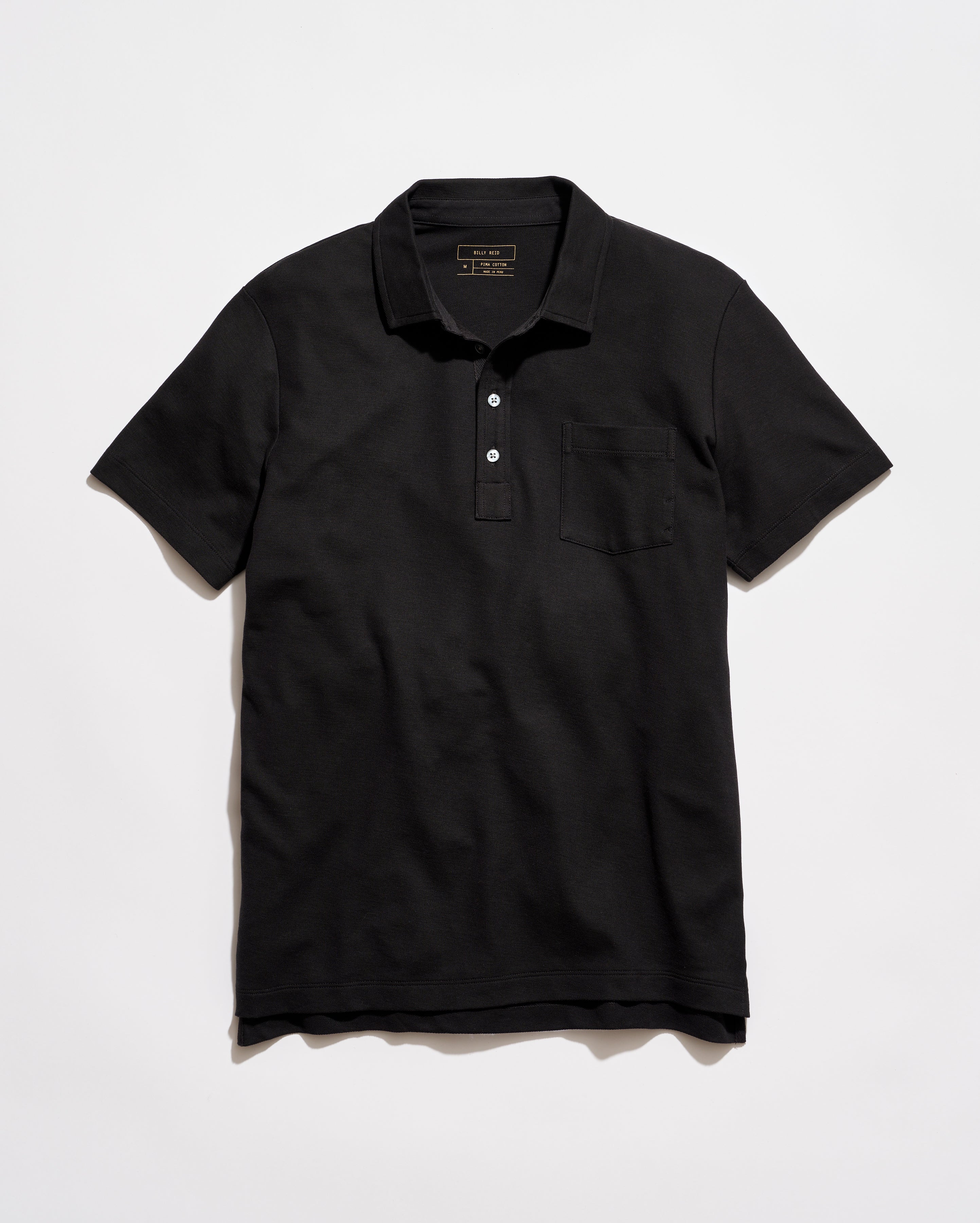 Black polo shirt on a light gray background