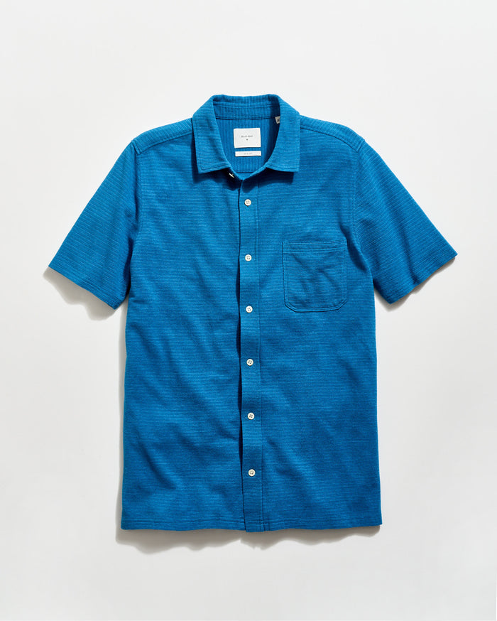 Blue short-sleeve shirt with a collar on a light gray background