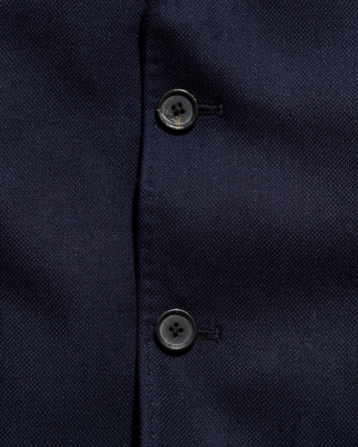 Close-up of a navy blue textured fabric with buttons
