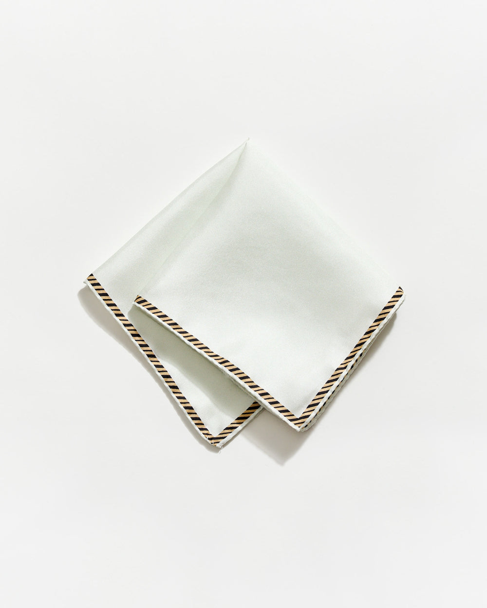 White napkin with gold trim on a white background