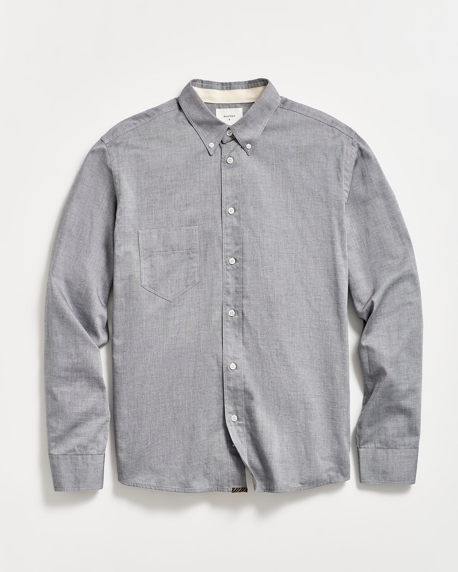 A light gray, long-sleeve button-down shirt with a single chest pocket, buttoned collar, and white buttons, laid flat on a white background.