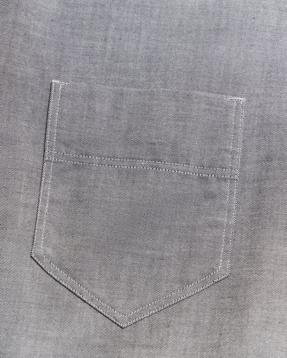 Close-up of a gray denim fabric with a stitched pocket, showing detailed texture and visible seam lines.