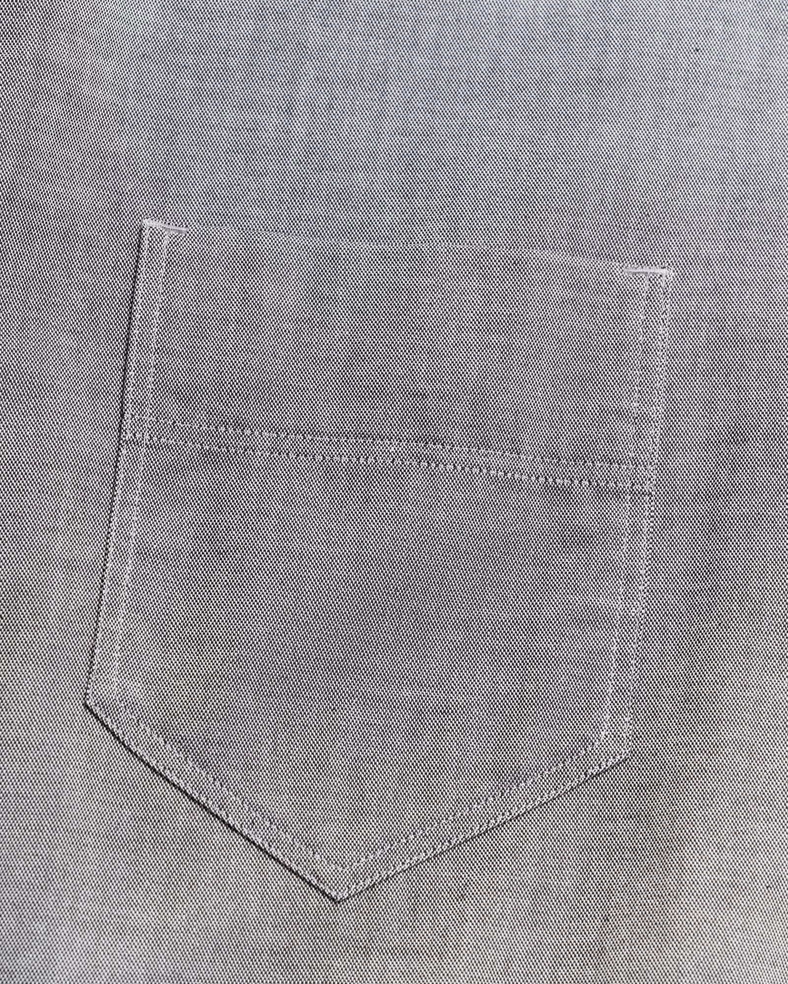 Close-up of a gray denim fabric with a stitched pocket, showing detailed texture and visible seam lines.