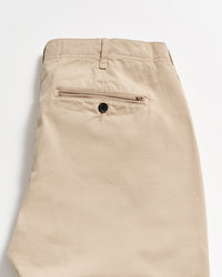 Beige khaki pants folded neatly, showing the back side with a single welt pocket featuring a black button. The fabric appears smooth, and there is a belt loop at the waistband.